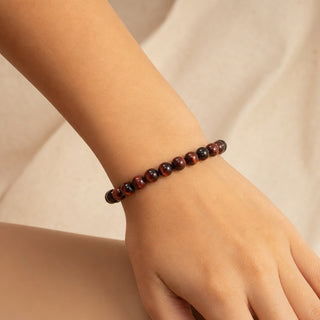 Red Tiger's Eye bead bracelet worn on the wrist, close-up
