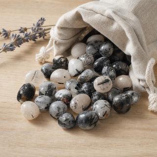 Tourmalinated Quartz Tumbled Stones spilling from a linen pouch