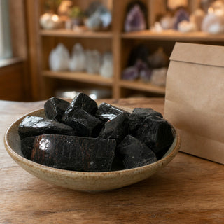 Tourmaline and Hematite Tumbled Stone - Free Form - 1lb in a ceramic bowl on a shop counter