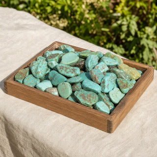 Turquoise Blue/Green Tumbled Stones in a wooden tray at a market stall