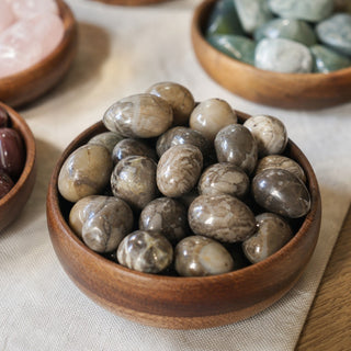 Volcano Agate Tumbled Stones in a wooden bowl on a boutique display table