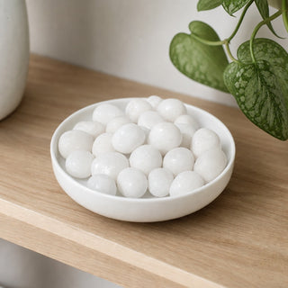 White Jade Tumbled Stones in a stoneware dish on a shop shelf