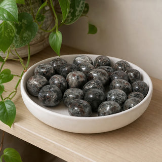Yooperlite Tumbled Stone in a stoneware dish on a shop shelf